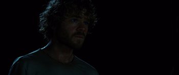 Movie still from “The Ruins” (2008), directed by Carter Smith – A person with curly hair; Close Up shot, Over the shoulder angle