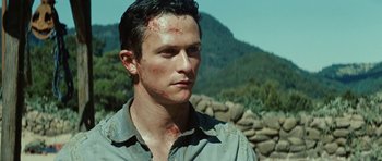 Movie still from “The Ruins” (2008), directed by Carter Smith – A young man with a scar on his face; Close Up shot, Over the shoulder angle