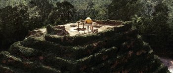 Movie still from “The Ruins” (2008), directed by Carter Smith – A man standing on top of a lush green hill; Extreme Wide shot, High angle