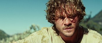 Movie still from “The Ruins” (2008), directed by Carter Smith – A person with curly brown hair; Close Up shot, Low angle