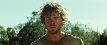 Movie still from “The Ruins” (2008), directed by Carter Smith – A person wearing a shirt; Close Up shot, Over the shoulder angle