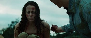 Movie still from “The Ruins” (2008), directed by Carter Smith – A woman with a bandage on her face and a man with a knife in her hand; Close Up shot, Over the shoulder angle