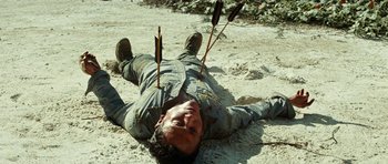 Movie still from “The Ruins” (2008), directed by Carter Smith – A man laying on the ground with arrows stuck in his head; Close Up shot, High angle