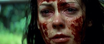 Movie still from “The Ruins” (2008), directed by Carter Smith – A person with blood on their face; Close Up shot, Overhead angle
