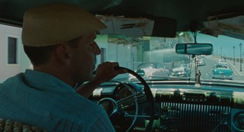 Movie still from “The Rum Diary” (2011), directed by Bruce Robinson – A man driving a car in the rain; Medium shot, Over the shoulder angle