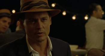 Movie still from “The Rum Diary” (2011), directed by Bruce Robinson – A person wearing a suit and a hat; Close Up shot, Over the shoulder angle