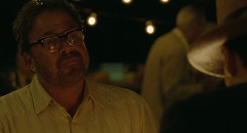 Movie still from “The Rum Diary” (2011), directed by Bruce Robinson – A person wearing glasses and a yellow shirt; Close Up shot, Over the shoulder angle