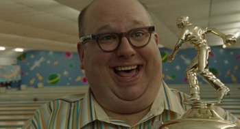 Movie still from “The Rum Diary” (2011), directed by Bruce Robinson – A person wearing glasses and smiling; Close Up shot, Low angle