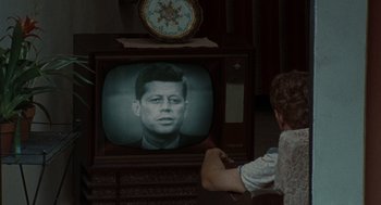 Movie still from “The Rum Diary” (2011), directed by Bruce Robinson – A person watching a television with a picture of john f; Close Up shot, Over the shoulder angle