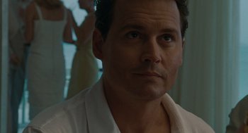 Movie still from “The Rum Diary” (2011), directed by Bruce Robinson – A person wearing a white shirt; Close Up shot, Over the shoulder angle