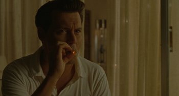 Movie still from “The Rum Diary” (2011), directed by Bruce Robinson – A man is smoking a cigarette in a room; Close Up shot, High angle