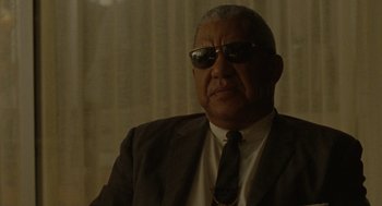 Movie still from “The Rum Diary” (2011), directed by Bruce Robinson – An older man wearing a suit and sunglasses; Close Up shot, Low angle