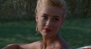 Movie still from “The Rum Diary” (2011), directed by Bruce Robinson – A beautiful blonde woman with red lipstick and earrings; Close Up shot, Over the shoulder angle