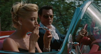 Movie still from “The Rum Diary” (2011), directed by Bruce Robinson – A man and a woman sitting in the back seat of a car; Close Up shot, Low angle