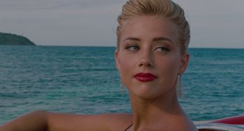 Movie still from “The Rum Diary” (2011), directed by Bruce Robinson – A beautiful blonde woman with red lipstick looking at the camera; Close Up shot, Over the shoulder angle