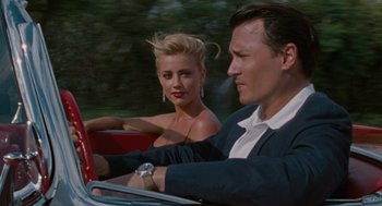 Movie still from “The Rum Diary” (2011), directed by Bruce Robinson – A man and a woman driving a car in the road; Close Up shot, Low angle