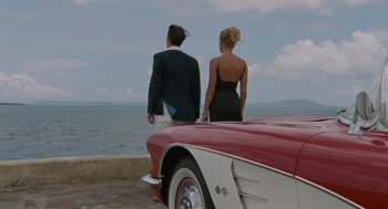 Movie still from “The Rum Diary” (2011), directed by Bruce Robinson – A man and a woman standing on the hood of a car; Wide shot, High angle