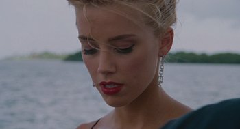 Movie still from “The Rum Diary” (2011), directed by Bruce Robinson – A beautiful blonde haired woman wearing a pair of earrings; Close Up shot, Over the shoulder angle