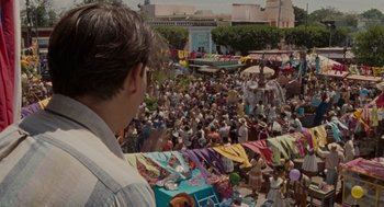 Movie still from “The Rum Diary” (2011), directed by Bruce Robinson – A crowd of people gathered in a market area; Extreme Wide shot, High angle