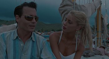 Movie still from “The Rum Diary” (2011), directed by Bruce Robinson – A man and a woman sitting on a sailboat; Close Up shot, Over the shoulder angle