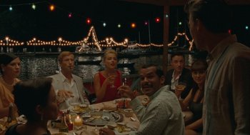 Movie still from “The Rum Diary” (2011), directed by Bruce Robinson – A group of people sitting at a table with food; Wide shot, High angle