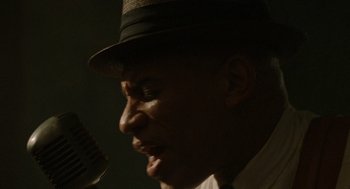 Movie still from “The Rum Diary” (2011), directed by Bruce Robinson – A person singing into a microphone; Extreme Close Up shot, Low angle