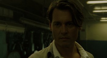 Movie still from “The Rum Diary” (2011), directed by Bruce Robinson – A man with long brown hair wearing a white shirt; Close Up shot, Low angle