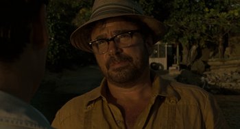 Movie still from “The Rum Diary” (2011), directed by Bruce Robinson – A person wearing glasses and a hat; Close Up shot, Over the shoulder angle