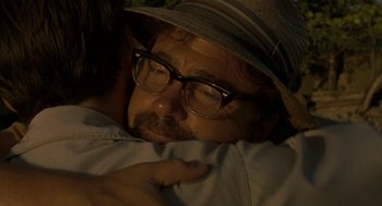 Movie still from “The Rum Diary” (2011), directed by Bruce Robinson – A person wearing glasses and a hat; Close Up shot, Over the shoulder angle