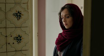 Movie still from “The Salesman” (2016), directed by Asghar Farhadi – A woman wearing a red head scarf and a black jacket; Close Up shot, Over the shoulder angle