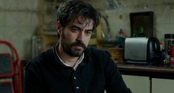 Movie still from “The Salesman” (2016), directed by Asghar Farhadi – A man sitting in a room with a beard; Close Up shot, Over the shoulder angle