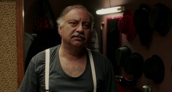 Movie still from “The Salesman” (2016), directed by Asghar Farhadi – An older man with a mustache wearing a black shirt; Close Up shot, Over the shoulder angle