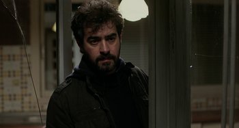 Movie still from “The Salesman” (2016), directed by Asghar Farhadi – A man with a beard is standing in front of a door; Close Up shot, Over the shoulder angle