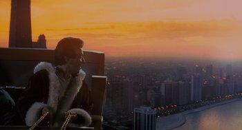 Movie still from “The Santa Clause” (1994), directed by John Pasquin – A man sitting in a chair looking out over a city at sunset; Extreme Wide shot, High angle
