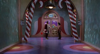 Movie still from “The Santa Clause” (1994), directed by John Pasquin – Two people are standing in a room with candy canes on the walls; Extreme Wide shot, High angle