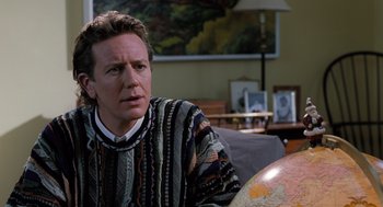 Movie still from “The Santa Clause” (1994), directed by John Pasquin – A man sitting in front of a globe in a living room; Close Up shot, Over the shoulder angle