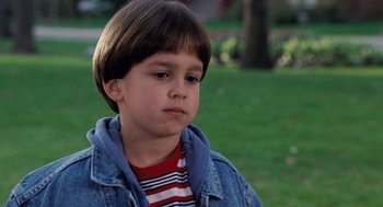 Movie still from “The Santa Clause” (1994), directed by John Pasquin – A young boy in a denim jacket and striped shirt; Close Up shot, High angle