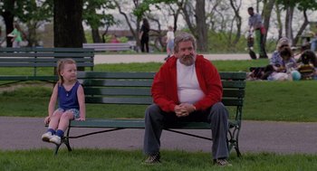 Movie still from “The Santa Clause” (1994), directed by John Pasquin – An older man sitting on top of a green park bench; Wide shot, Over the shoulder angle