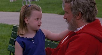 Movie still from “The Santa Clause” (1994), directed by John Pasquin – An older man sitting next to a little girl on a park bench; Medium shot, Over the shoulder angle