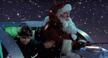 Movie still from “The Santa Clause” (1994), directed by John Pasquin – A man dressed as santa claus sitting next to a boy; Medium shot, Low angle