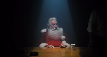 Movie still from “The Santa Clause” (1994), directed by John Pasquin – A man dressed as santa claus sitting at a dinner table; Medium shot, Low angle