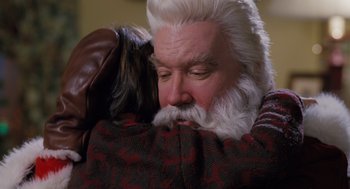 Movie still from “The Santa Clause” (1994), directed by John Pasquin – An old man with a long white beard hugging a dog; Close Up shot, High angle