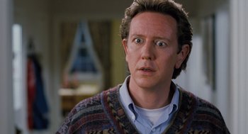 Movie still from “The Santa Clause” (1994), directed by John Pasquin – A person wearing a sweater and looking surprised; Close Up shot, Over the shoulder angle