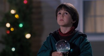 Movie still from “The Santa Clause” (1994), directed by John Pasquin – A young boy holding a snow globe in his hands; Close Up shot, Low angle