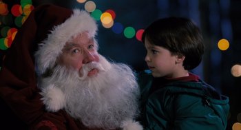 Movie still from “The Santa Clause” (1994), directed by John Pasquin – A child is standing next to a santa clause; Close Up shot, Over the shoulder angle