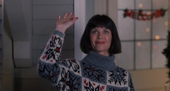 Movie still from “The Santa Clause” (1994), directed by John Pasquin – A woman wearing a sweater waving at the camera; Medium shot, Low angle