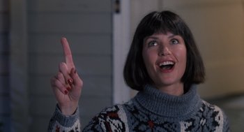 Movie still from “The Santa Clause” (1994), directed by John Pasquin – A woman in a sweater is holding up a finger; Close Up shot, Low angle