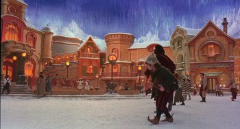 Movie still from “The Santa Clause 2” (2002), directed by Michael Lembeck – Two children are walking in the snow in front of a gingerbread house; Extreme Wide shot, High angle