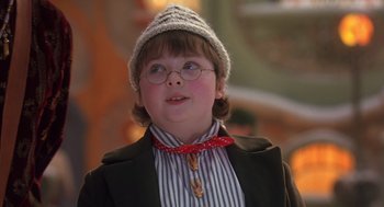 Movie still from “The Santa Clause 2” (2002), directed by Michael Lembeck – A young boy wearing glasses and wearing a hat; Close Up shot, High angle