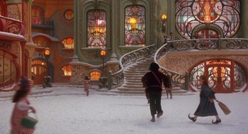 Movie still from “The Santa Clause 2” (2002), directed by Michael Lembeck – A group of people standing around a building with stained - glass windows; Extreme Wide shot, Low angle